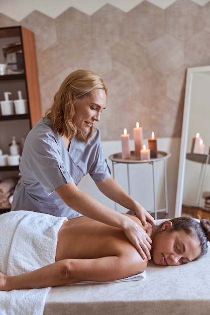 Foto junge attraktive frau im massagesalon hat schönheits- und gesundheitsverfahren