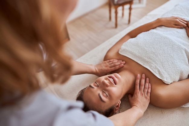 Foto junge attraktive frau im massagesalon hat schönheits- und gesundheitsverfahren