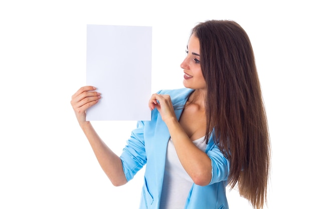 Junge attraktive Frau in blauer Jacke, die die Hälfte ihres Gesichts hinter einem weißen Blatt Papier versteckt