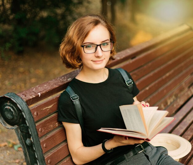 Junge attraktive Frau mit kurzem Haarschnitt und Brille liest