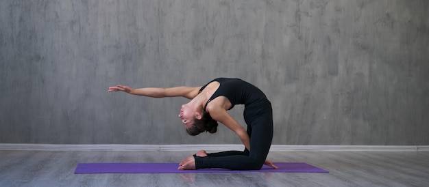 Junge attraktive kaukasische Frau, die Yoga tut, sitzt in Trainingsyoga-Pose