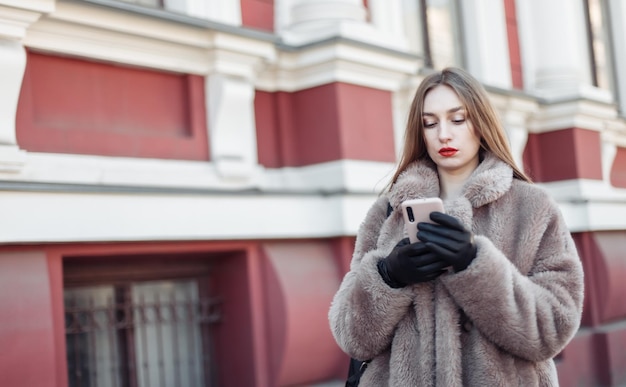 Junge attraktive Mode blonde Frau mit Smartphone in der Stadt