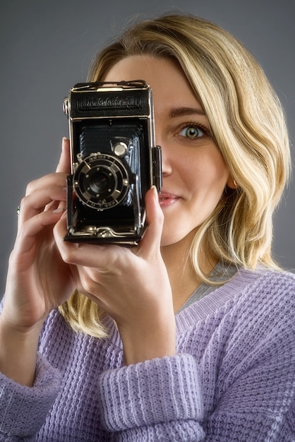 Junge attraktive Womanwith Vintage tragbare Kamera