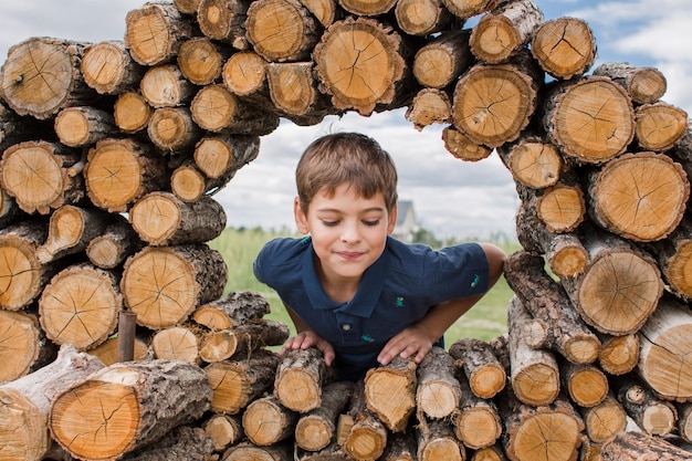 Junge auf dem Feld auf dem Bauernhof und Brennholz