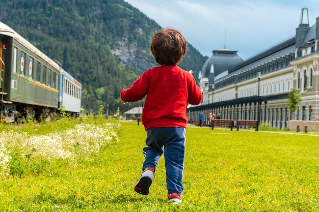 Junge auf dem Rücken läuft im alten Bahnhof von Canfranc in den Pyrenäen Spaniens