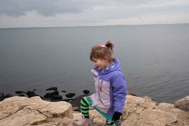 Junge auf einem Felsen am Meer