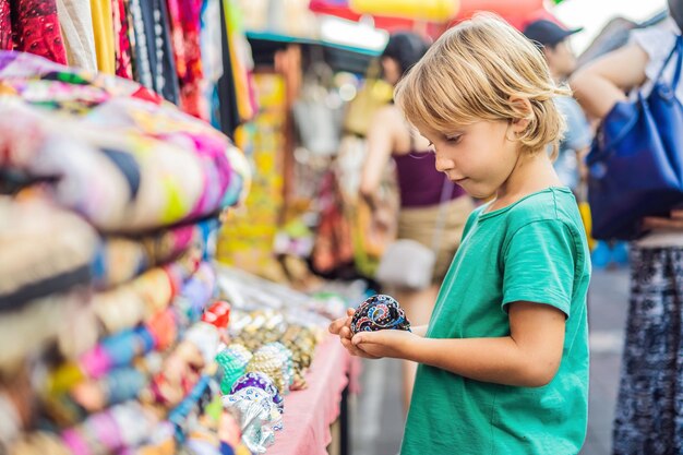 Foto junge auf einem markt in ubud bali typischer souvenirladen mit souvenirs und kunsthandwerk aus bali auf dem berühmten markt von ubud indonesien balinesischer markt souvenirs aus holz und kunsthandwerk der anwohner