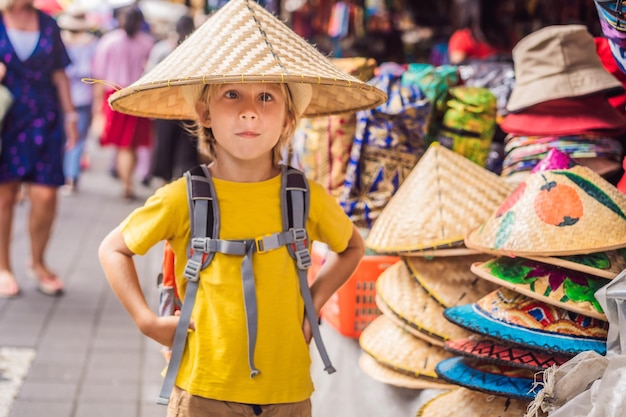 Junge auf einem Markt in Ubud Bali Typischer Souvenirladen mit Souvenirs und Kunsthandwerk aus Bali auf dem berühmten Markt von Ubud Indonesien Balinesischer Markt Souvenirs aus Holz und Kunsthandwerk der Anwohner