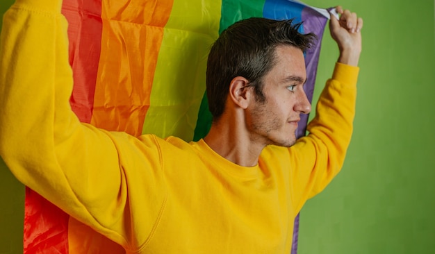 Junge auf Seite mit Regenbogenfahne auf grünem Hintergrund, lgbti, Homosexuell