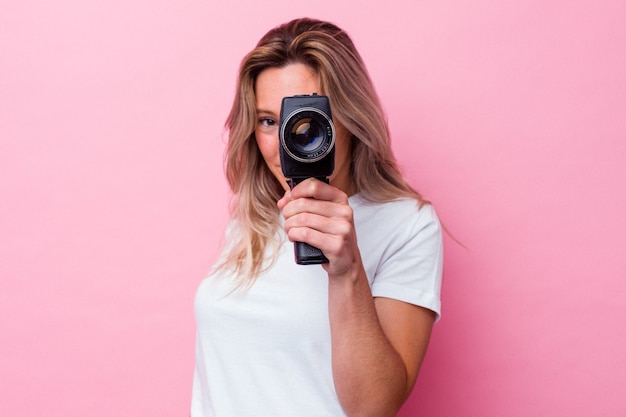 Junge australische Frau, die mit einer Weinlesevideokamera isoliert filmt