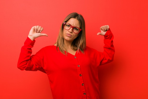 Junge authentische charismatische Frau an einer Wand fühlt sich stolz und selbstbewusst, Beispiel zu folgen