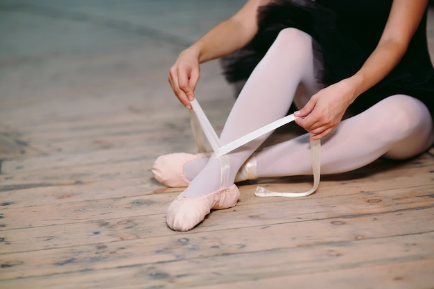 Foto junge ballerina im schwarzen kleid zieht hinter die kulissen.