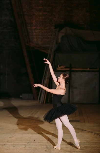 Junge Ballerina im schwarzen Kleid zieht hinter die Kulissen.