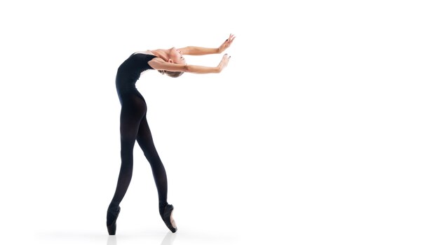 Junge Ballerina in schwarzen Spitzenschuhen und Trikots posiert in anmutiger Pose, isoliert auf weißem Hintergrund