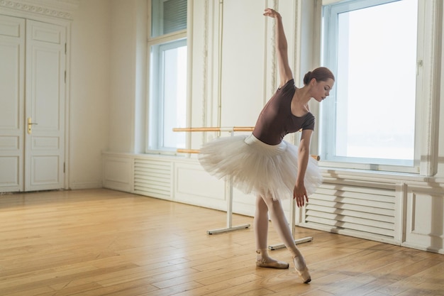 Junge Ballerina in Tutu-Rücken tanzt, übt Ballettpositionen in der Tanzklasse, junge Klassikerin