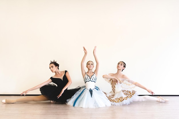 Junge Ballerinas führen im Studio Paarübungen vor weißem Hintergrund durch