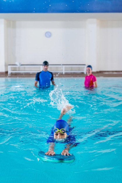 Junge beim Schwimmunterricht mit einem Lehrer