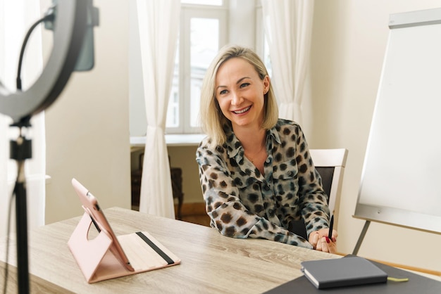 Junge Bloggerin oder Coach während der Online-Übertragung zu Hause oder im kleinen Büro