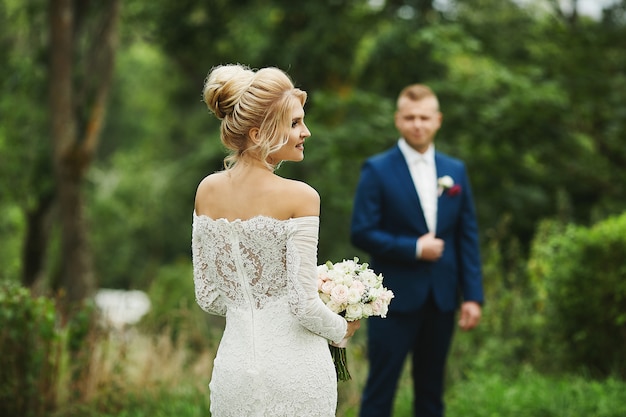 Junge blonde Braut mit ihrem hübschen Bräutigam