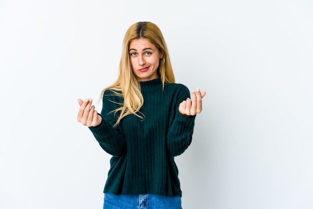 Junge blonde Frau auf weißer Wand zeigt, dass sie kein Geld hat.