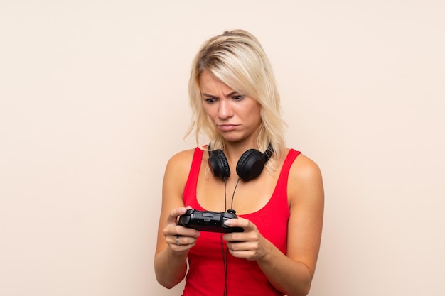 Junge blonde Frau, die an den Videospielen spielt