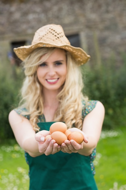 Foto junge blonde frau, die eier zeigt