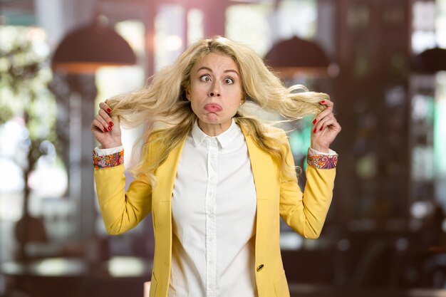 Foto junge blonde frau, die eine grimasse macht. junge frau, die lustiges gesicht macht.