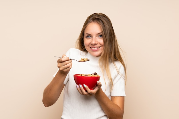 Junge blonde Frau, die eine Schüssel Getreide anhält