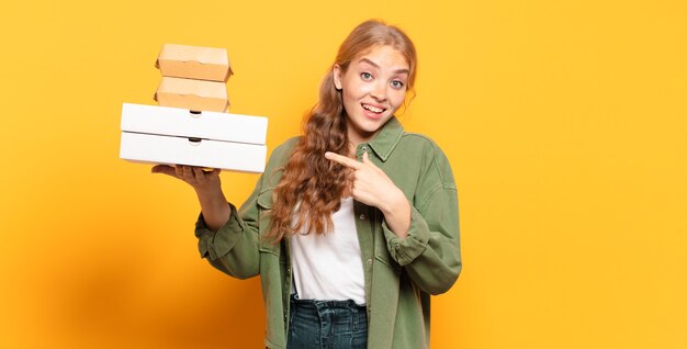 Junge blonde Frau, die Fast Food wegnimmt