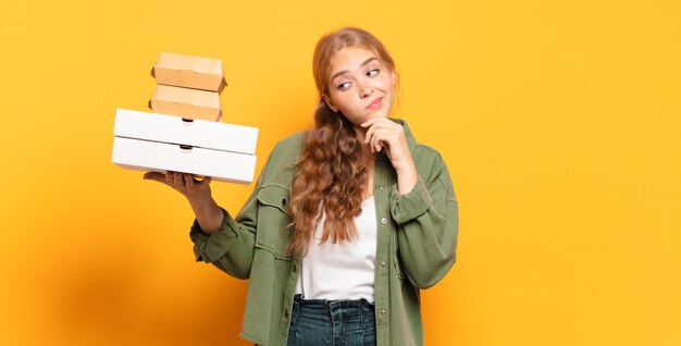 Junge blonde Frau, die Fast Food wegnimmt