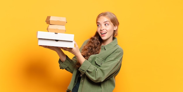 Junge blonde Frau, die Fast Food wegnimmt