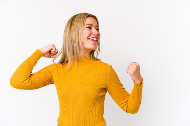 Junge blonde Frau, die Faust nach einem Sieg erhebt