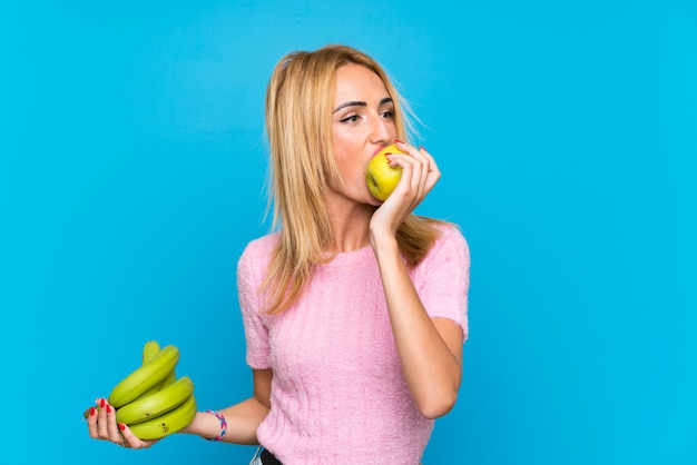 Junge blonde Frau, die Früchte anhält