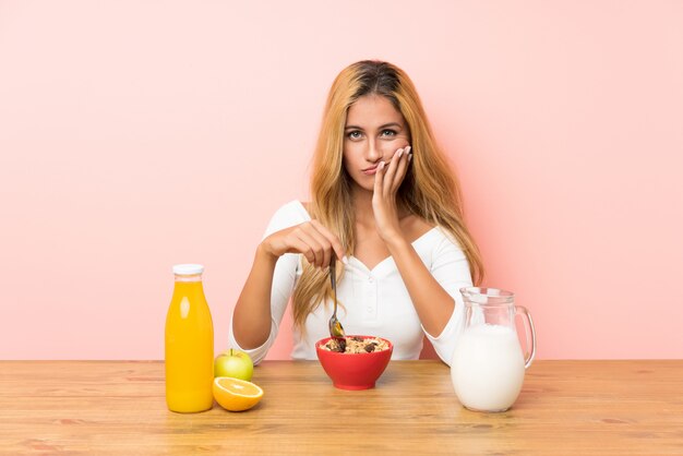 Junge blonde Frau, die Frühstücksmilch hat