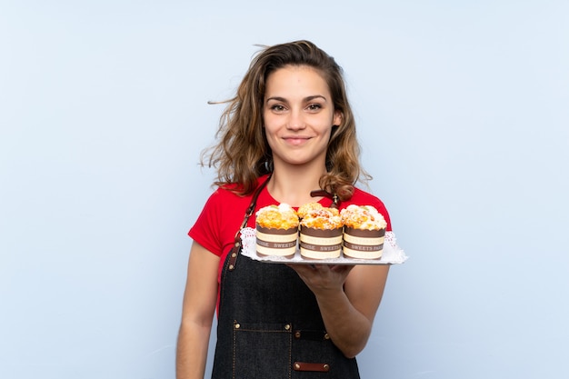 Junge blonde Frau, die Minikuchen anhält