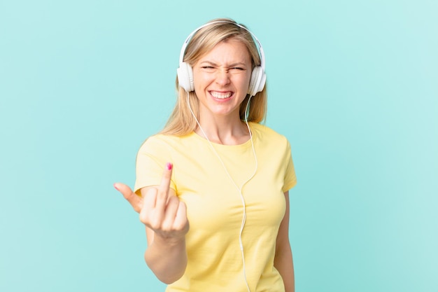 Junge blonde Frau, die sich wütend, verärgert, rebellisch und aggressiv fühlt und Musik hört.