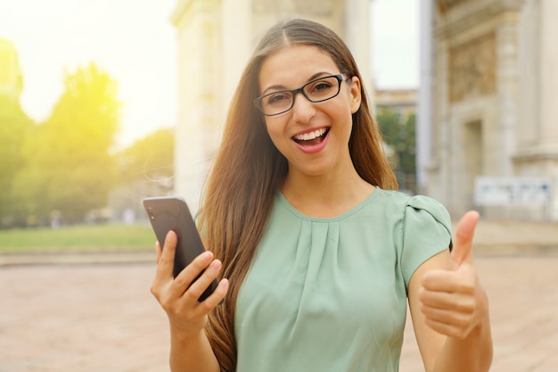 Junge blonde Frau hält Telefon