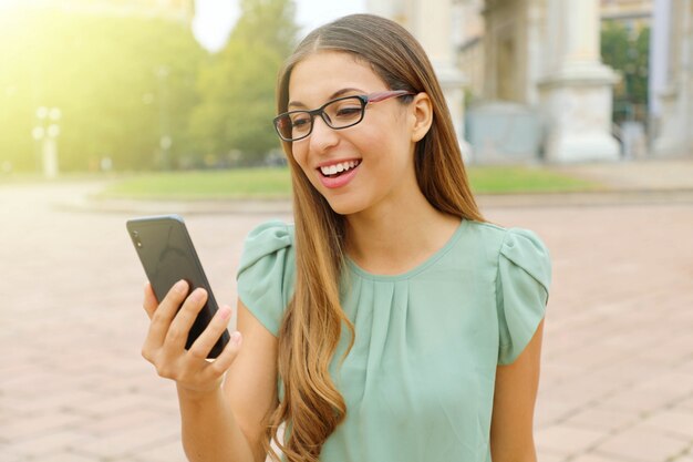 Junge blonde Frau hält Telefon