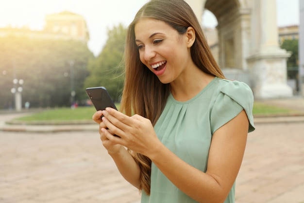 Junge blonde Frau hält Telefon