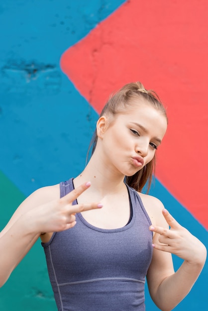 Junge blonde Frau in Sportbekleidung im Freien Trainingsporträt, mehrfarbiger Hintergrund