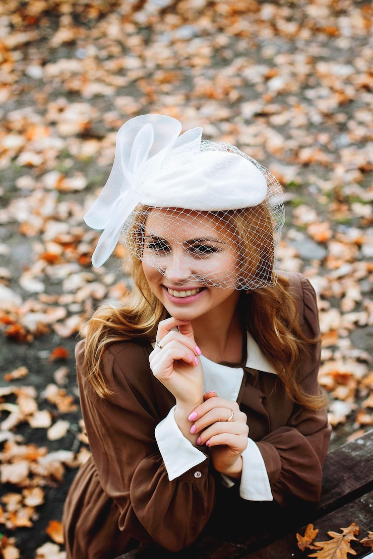 Foto junge blonde frau in vintage-kleidung sitzt mit einem blatt im herbstpark