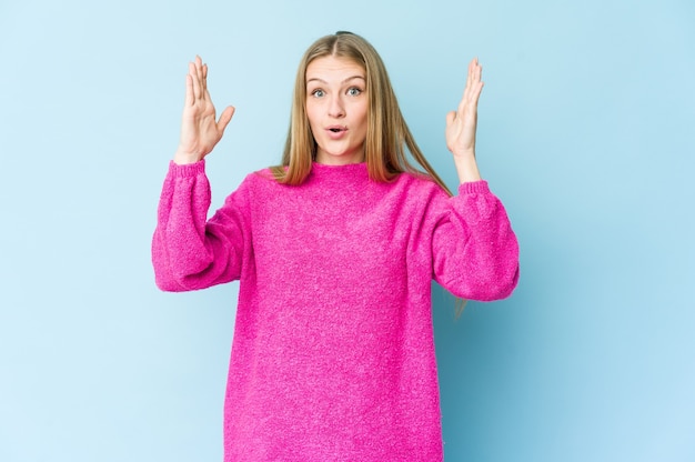 Junge blonde Frau lokalisiert auf blauem Hintergrund, der eine Idee, Inspirationskonzept hat.