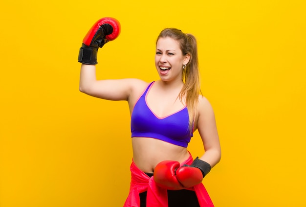 Junge blonde Frau mit Boxhandschuhen