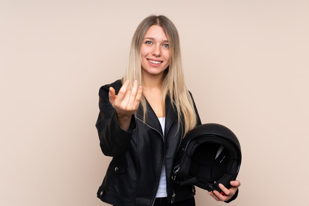 Junge blonde Frau mit einem Motorradhelm, der einlädt, zu kommen