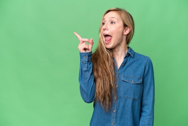 Junge blonde Frau mit isoliertem Hintergrund, die beabsichtigt, die Lösung zu realisieren, während sie einen Finger hebt