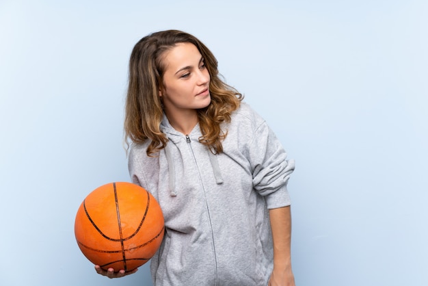 Junge blonde Frau mit Kugel des Basketballs