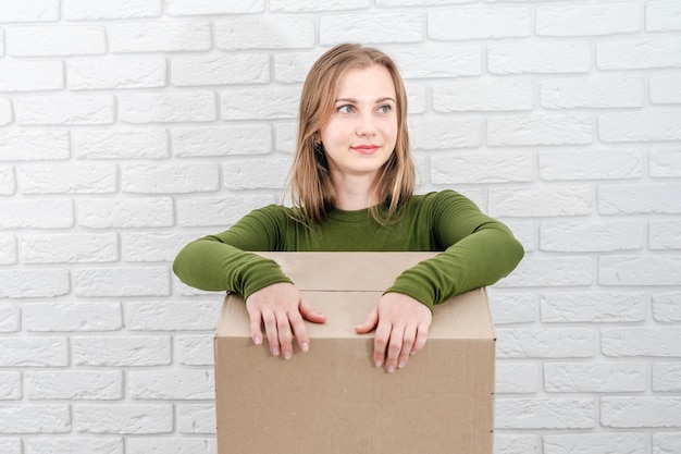 Junge blonde Frau mit Paketkasten Zustellung eines Pakets