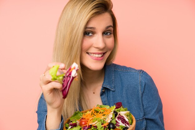 Junge blonde Frau mit Salat