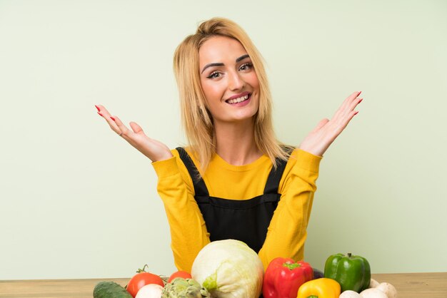 Junge blonde Frau mit viel Gemüse lachen