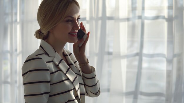 Foto junge blonde frau telefoniert im fenster, exemplar